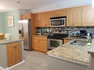 a kitchen with wooden cabinets and stainless steel appliances at 2BR/1BA Vacation Rental - Sienna Park in Sarasota