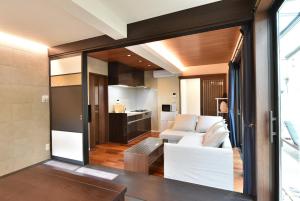 a living room with a white couch and a kitchen at ASAKUSA EAST Terrace - KANDO in Tokyo