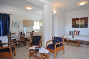 a living room with a table and chairs and a kitchen at Eri Hotel in Parikia