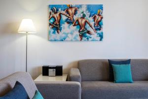 een woonkamer met een bank en een schilderij aan de muur bij Synergy Broadbeach - Official in Gold Coast