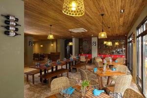 a restaurant with wooden ceilings and tables and chairs at Lagùn Hotel in El Nido