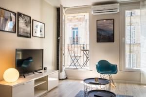 マルセイユにあるconfortable appartement prado castellaneのリビングルーム(テレビ、椅子付)
