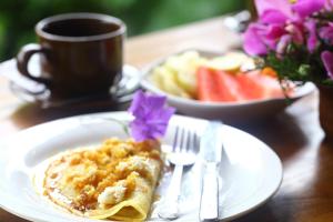 a table with a plate of food and a cup of coffee at Loka Sari Guest House and Spa in Ubud