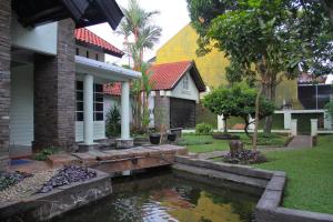 a house with a pond in front of a house at Little Creek Lodge in Malang