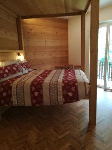 um quarto com uma cama num chalé de madeira em Romantiche Orobie B&B em Bordogna