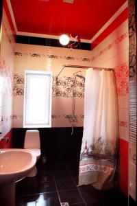 a bathroom with a shower curtain and a sink at Hotel Usadba in Georgiyevsk