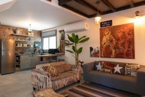a living room with a couch and a refrigerator at Inspirational Apartment in Tel Aviv