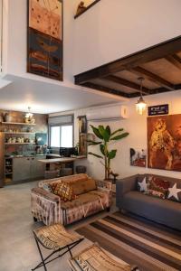 een woonkamer met 2 banken en een keuken bij Inspirational Apartment in Tel Aviv