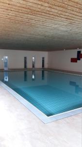 einem großen Pool in einem Gebäude mit einer Decke in der Unterkunft Ferienwohnung Stroh in Missen-Wilhams