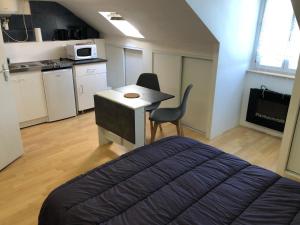 ein Schlafzimmer mit einem Bett und einem Schreibtisch mit Stuhl in der Unterkunft Residence Le Continental in Vittel