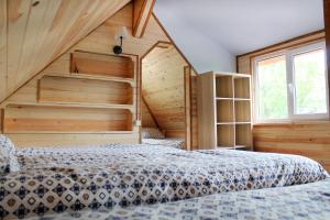 a bedroom with a bed in a room with wooden walls at Guest House Gravas in Bauska