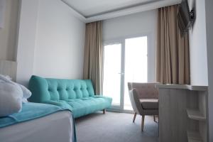a living room with a blue couch and a chair at Hotel Sol de Jávea in Jávea