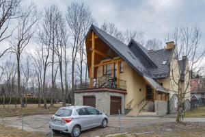 a house with a car parked in front of it at Apartament Krupowki CENTRUM in Zakopane