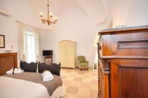 een slaapkamer met een bed en een kroonluchter bij Palazzo Rodio in Ostuni