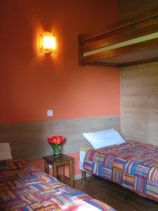 - une chambre avec 2 lits et un vase de fleurs sur une table dans l'établissement 8 Chalets - Les Lodges du Hérisson - à 1500m des cascades, à Bonlieu