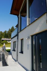 a building with large glass doors and a bench at Austrian Alpine Apartments in Ramsau am Dachstein