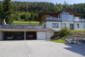 a large house with a garage with cars in it at Austrian Alpine Apartments in Ramsau am Dachstein