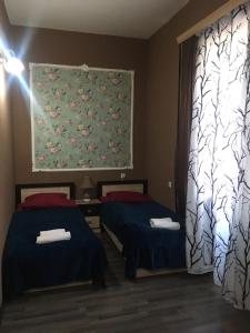 a room with two beds and a painting on the wall at Sweet Home Freedom Square in Tbilisi City