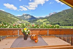 a table on a balcony with a view of mountains at Jaiterhof in Funes