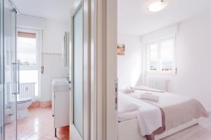 Habitación blanca con cama y baño. en Bilocale Via Forni, en Udine