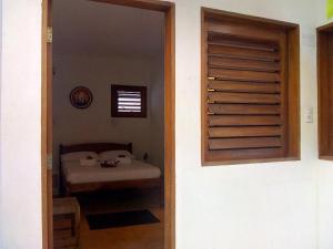 a door to a room with a table and a bed at Guaco House in Jericoacoara