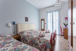 a bedroom with two beds and a table with shoes on it at Holiday in Milano Marittima