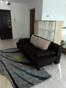 a black couch in a living room with a rug at Central Residence Constanta in Constanţa