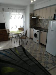 a kitchen with a table and chairs and a refrigerator at Central Residence Constanta in Constanţa