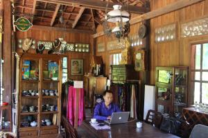 a man sitting at a table with a laptop at Soriyabori Villas Resort in Kratie