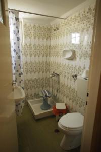 a bathroom with a toilet, sink, and bathtub at Evans Hotel in Heraklio