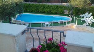 een zwembad met stoelen en een tafel bij B&B Villa Nonna Maria in Castellana Grotte