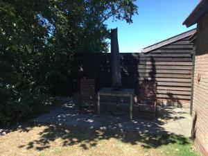 巴勒姆的住宿－Bungalow Halfweg，后院配有两把椅子和户外炉灶
