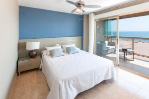 een slaapkamer met een wit bed en uitzicht op het strand bij Ag Bermudas Premium in Gandía +96 foto's