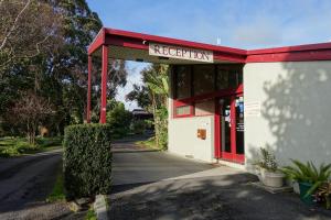 Korumburra煤溪汽车旅馆的红色和白色的建筑,有红色屋顶