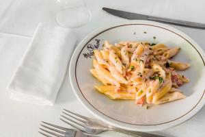 a plate of pasta on a table with a fork at Holiday in Milano Marittima