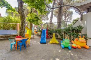 un parque infantil con mesa, sillas y equipo de juegos en Holiday, en Milano Marittima