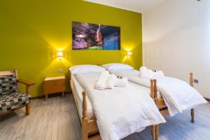 two beds in a room with a green wall at Affittacamere Al Canyon PUB BIRRERIA in Fondo