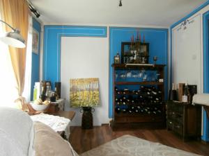 uma sala de estar com paredes azuis e um armário de vinhos em The Gates Apartments em Koprivshtitsa