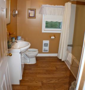 a bathroom with a sink and a toilet and a window at Trinity Suites in Trinity