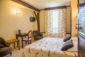 a bedroom with a bed and a table and chairs at Logis Hôtel Restaurant Château Bellevue in Cazaubon