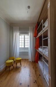 a small room with a bunk bed and a yellow stool at VisHostel in Viseu