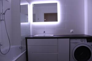 a bathroom with a sink and a washing machine at Park Vienna Hauptbahnhof Apartments in Vienna