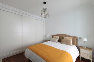 マドリードにあるSalamanca Premiumの白いベッドルーム(黄色い毛布付きのベッド付)
