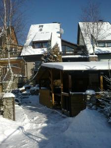 une maison avec de la neige au sol dans une cour dans l'établissement Penzión Skitour, à Stará Lesná