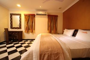 a bedroom with a bed and a checkered floor at Meenakshi's Sunshine Hotel in Madurai