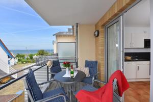 a balcony with a table and chairs and a kitchen at Bernstein Suite in Glowe