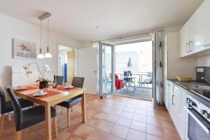 a kitchen and dining room with a table and chairs at Bernstein Suite in Glowe