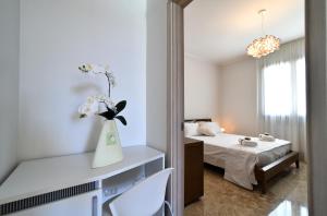 a white room with a bed and a vase with flowers at Villa Luigia Luxury Relais in Gallipoli +79 photos