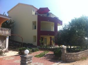a house with an umbrella on top of it at Apartments Villa Stella Maris in Rogoznica