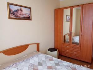 ピャチゴルスクにあるГостевой Дом Туристのベッドルーム1室(ベッド1台付)、木製キャビネットが備わります。